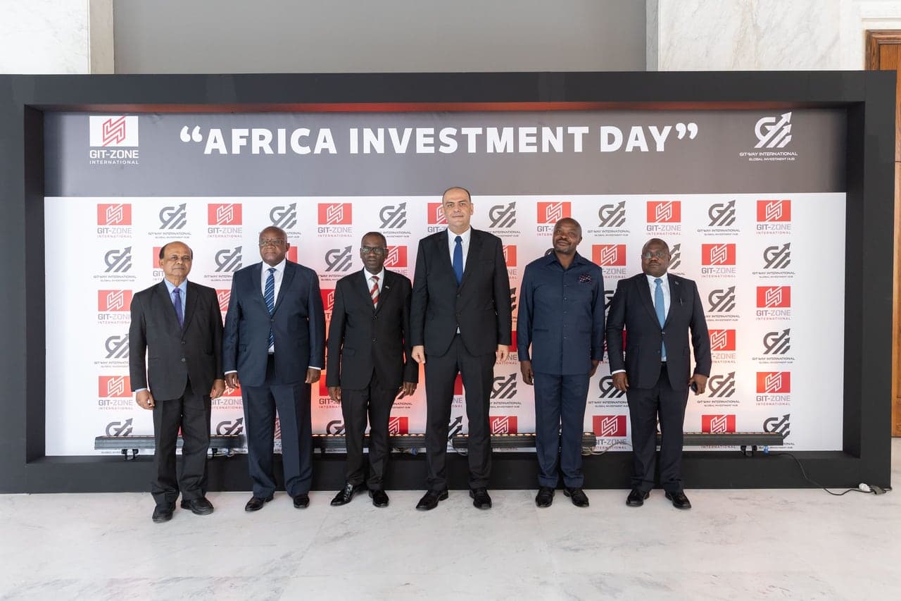 Delegates standing together in front of the Africa Investment Day flag wall.