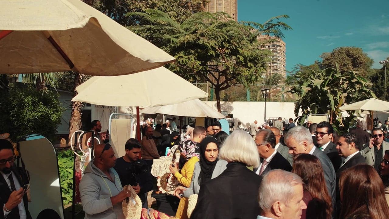 Visitors walking between the stalls under white umbrellas at the Forasna bazaar.