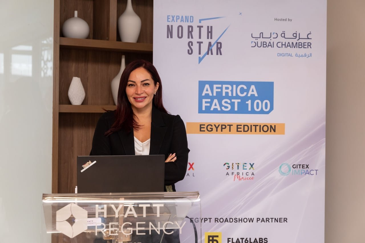 A speaker at a clear podium in front of the Africa FAST 100 Egypt Edition banner.