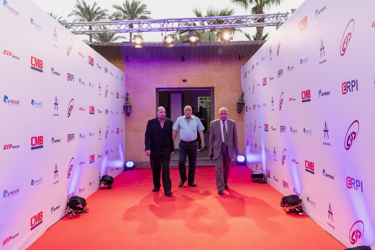 Guests walking the red carpet between two walls of partner logos.