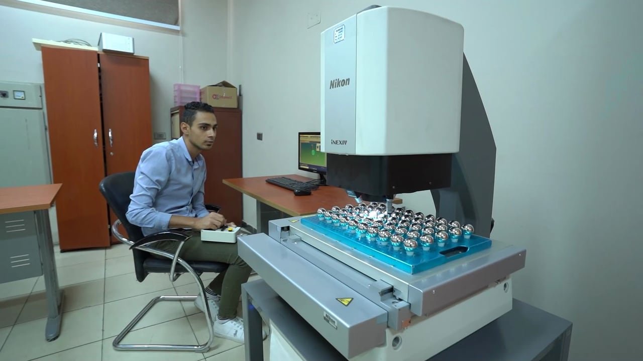 An engineer checking parts on a measuring machine.