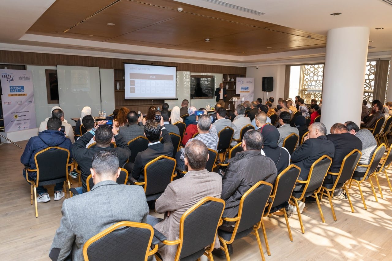 The audience following a presentation on screen, seen from the back of the room.