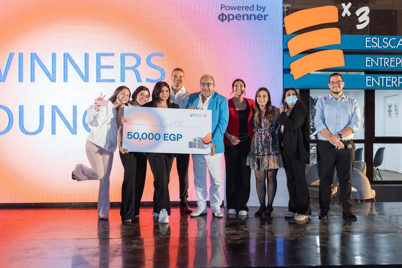 A winning startup team holding their cheque on stage at ESLSCA's EX3 Demo Day 3.