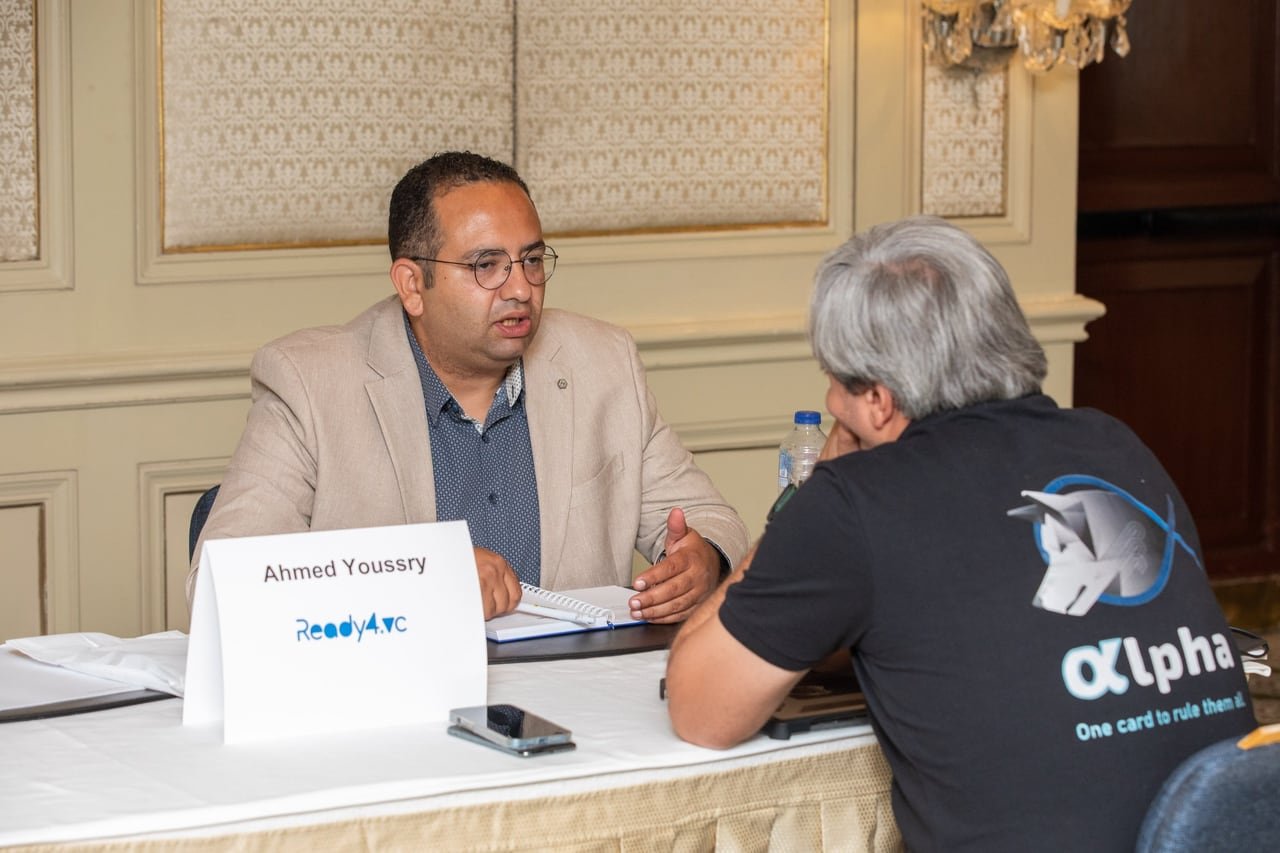 حوار بين مستثمر ومؤسس على طاولة عليها اسم المستثمر.