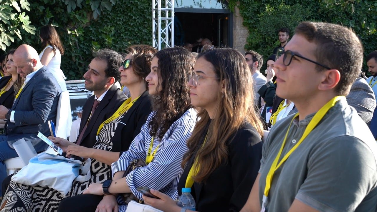 مؤسسون وضيوف يستمعون في الصفوف الأمامية.