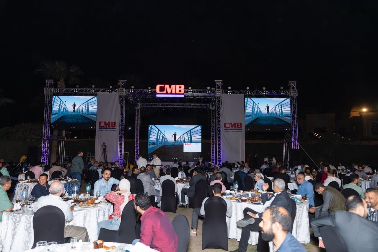 Full tables in front of the lit stage at night.