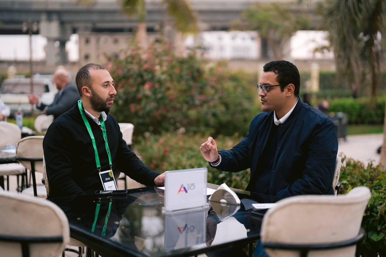 A founder and an investor in a one-to-one meeting at a branded table.