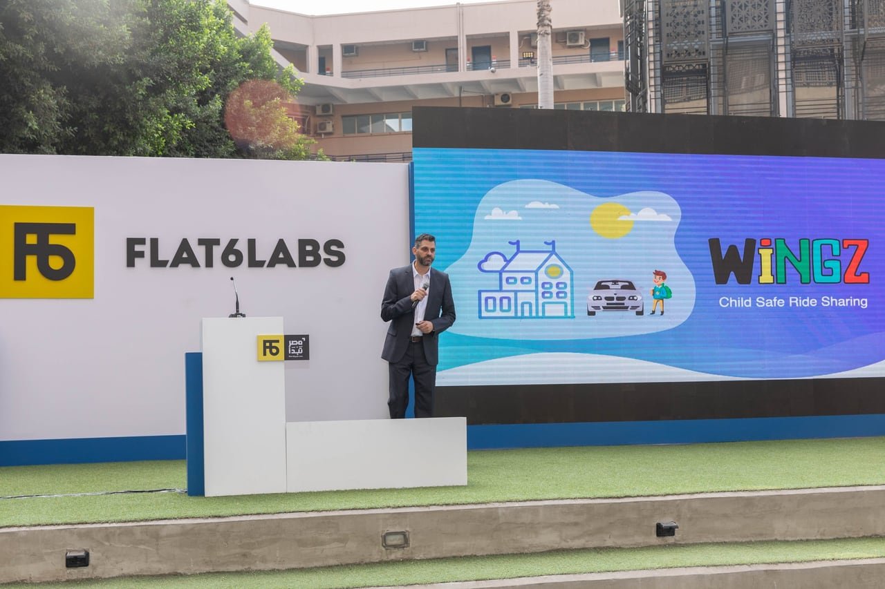 A founder pitching his startup in front of the screen.