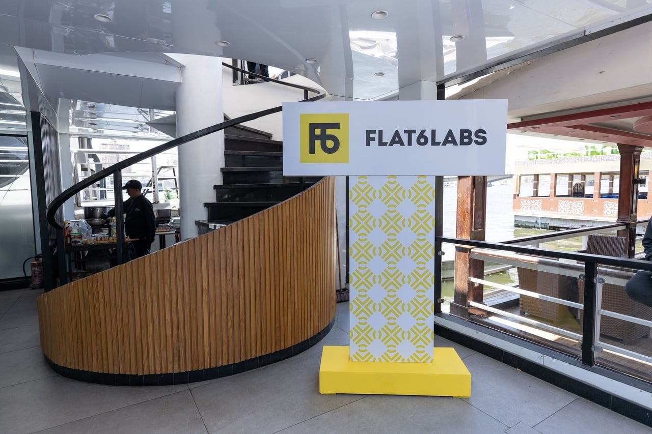 A Flat6Labs-yellow pillar by the wooden staircase.