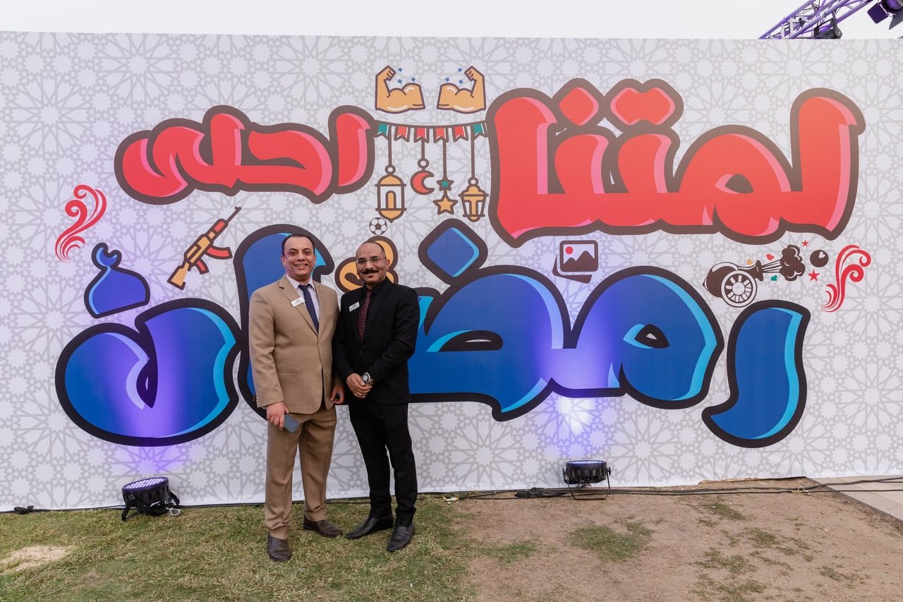 Two guests in front of the Ramadan backdrop.