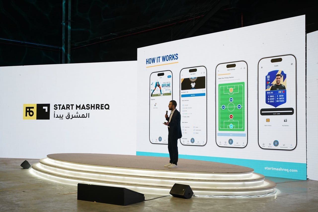 A speaker on the curved white stage at the StartMashreq Forum.