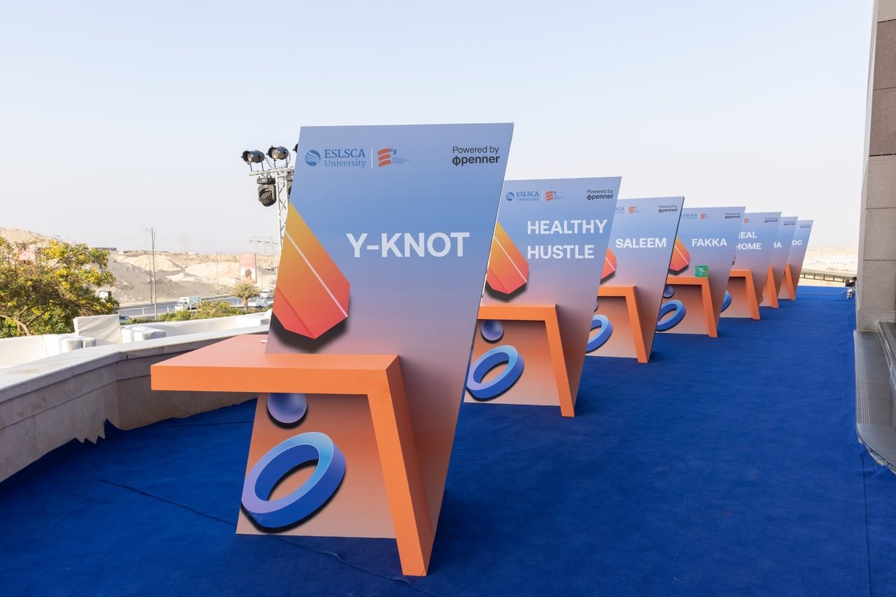 Stands carrying each startup’s name, lined along the blue carpet.