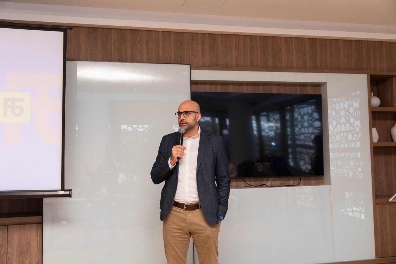 A speaker addressing the room, microphone in hand.