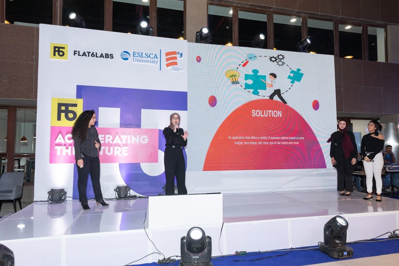 A founder presenting her project on stage at night.