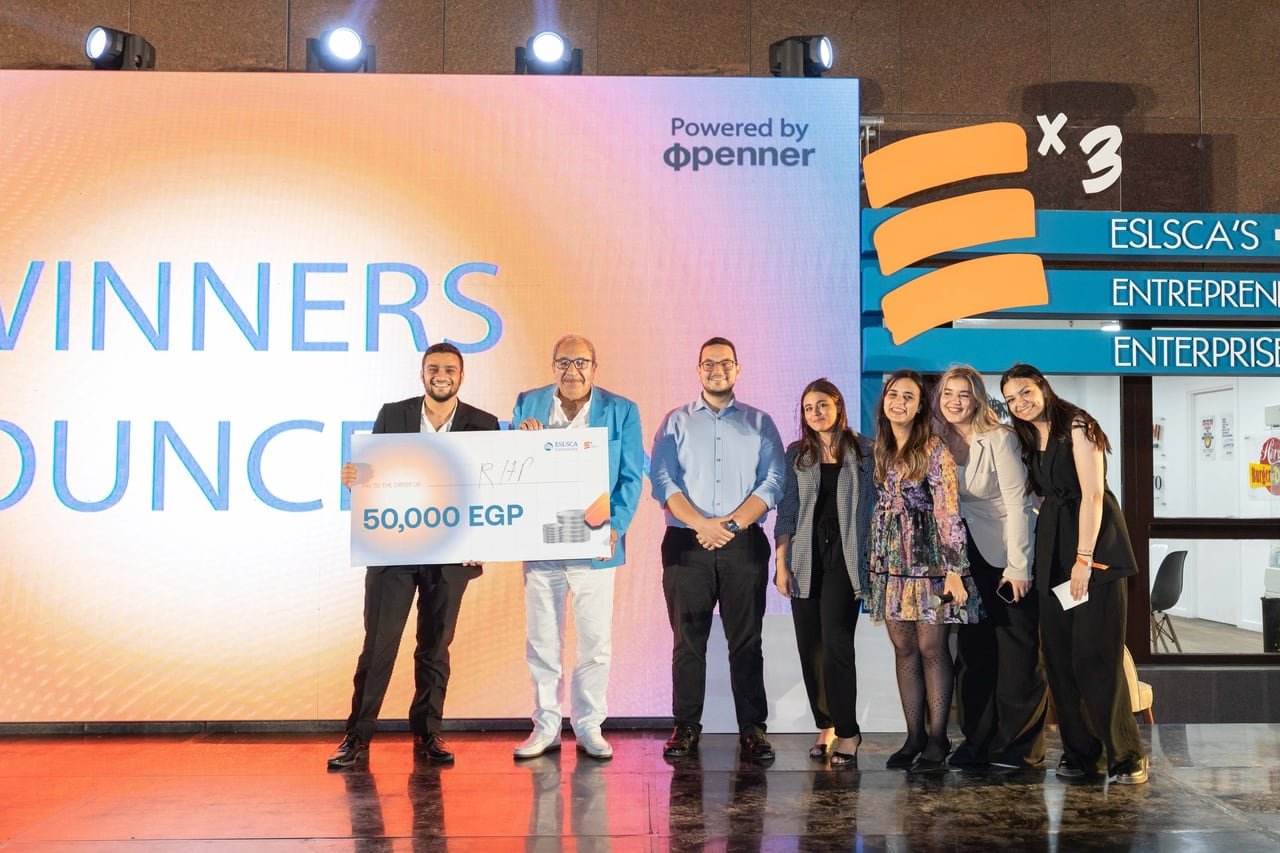 A winning team holding their 50,000 EGP cheque.