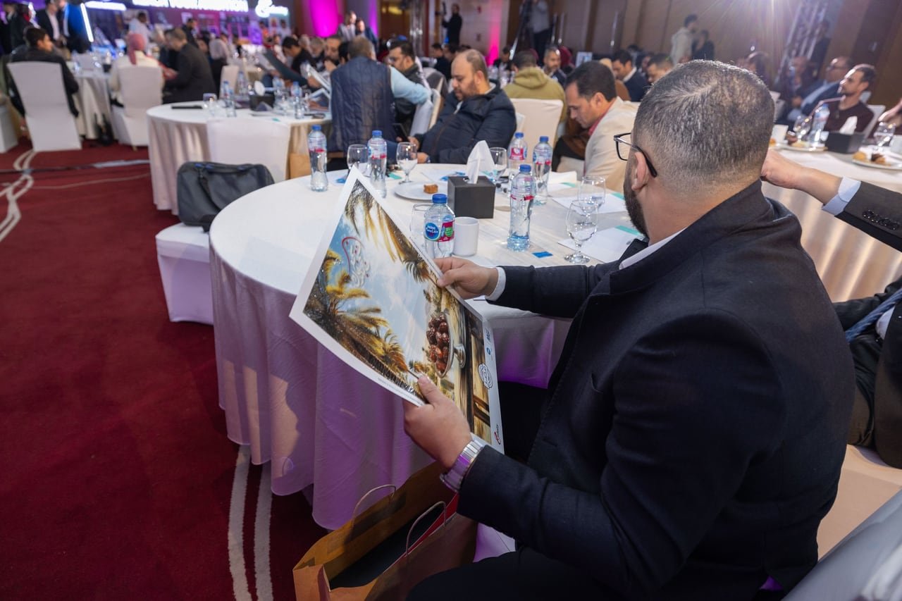 A guest looking at a print from his gift bag.