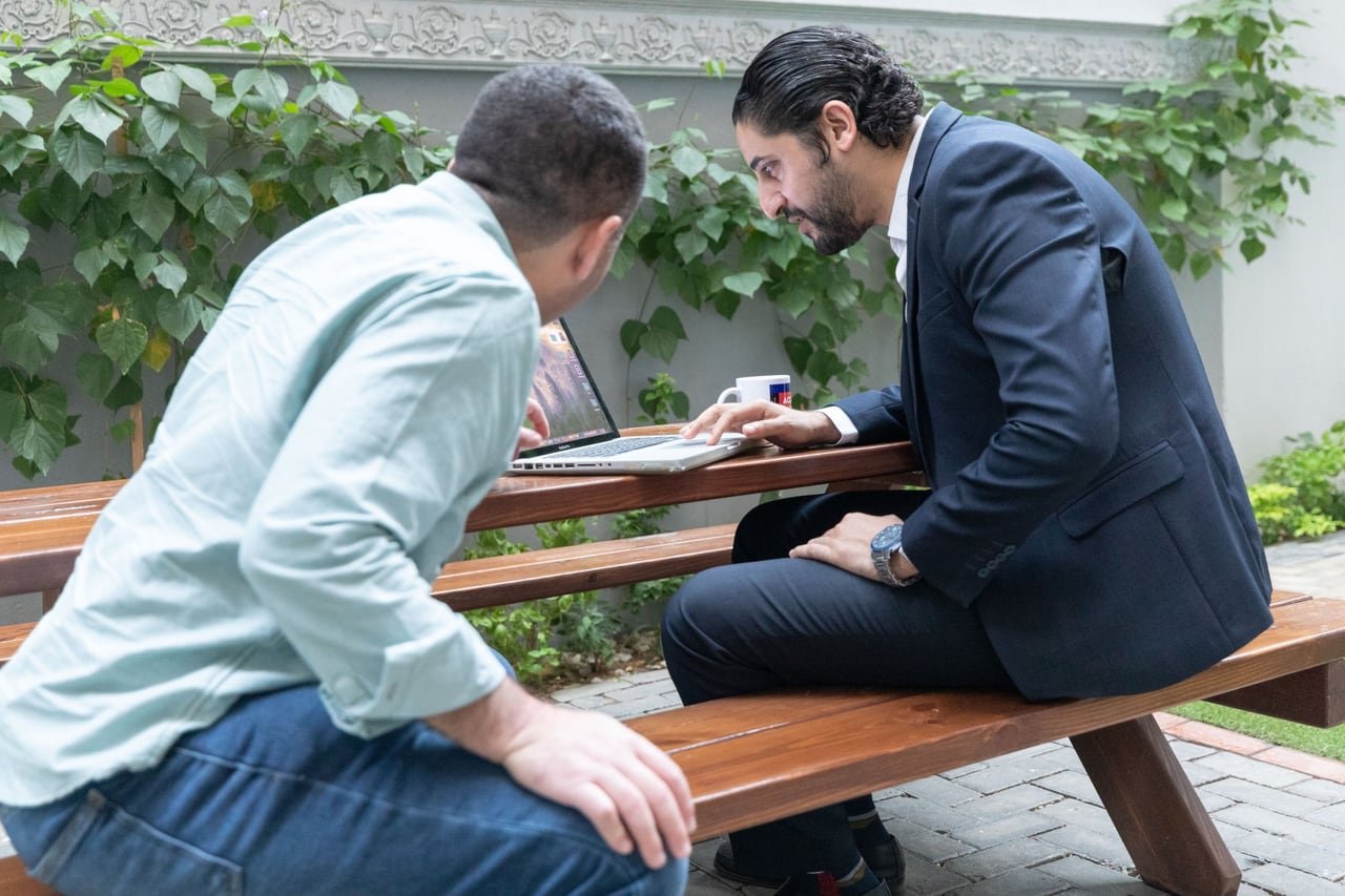 A conversation on a wooden bench in the office garden.