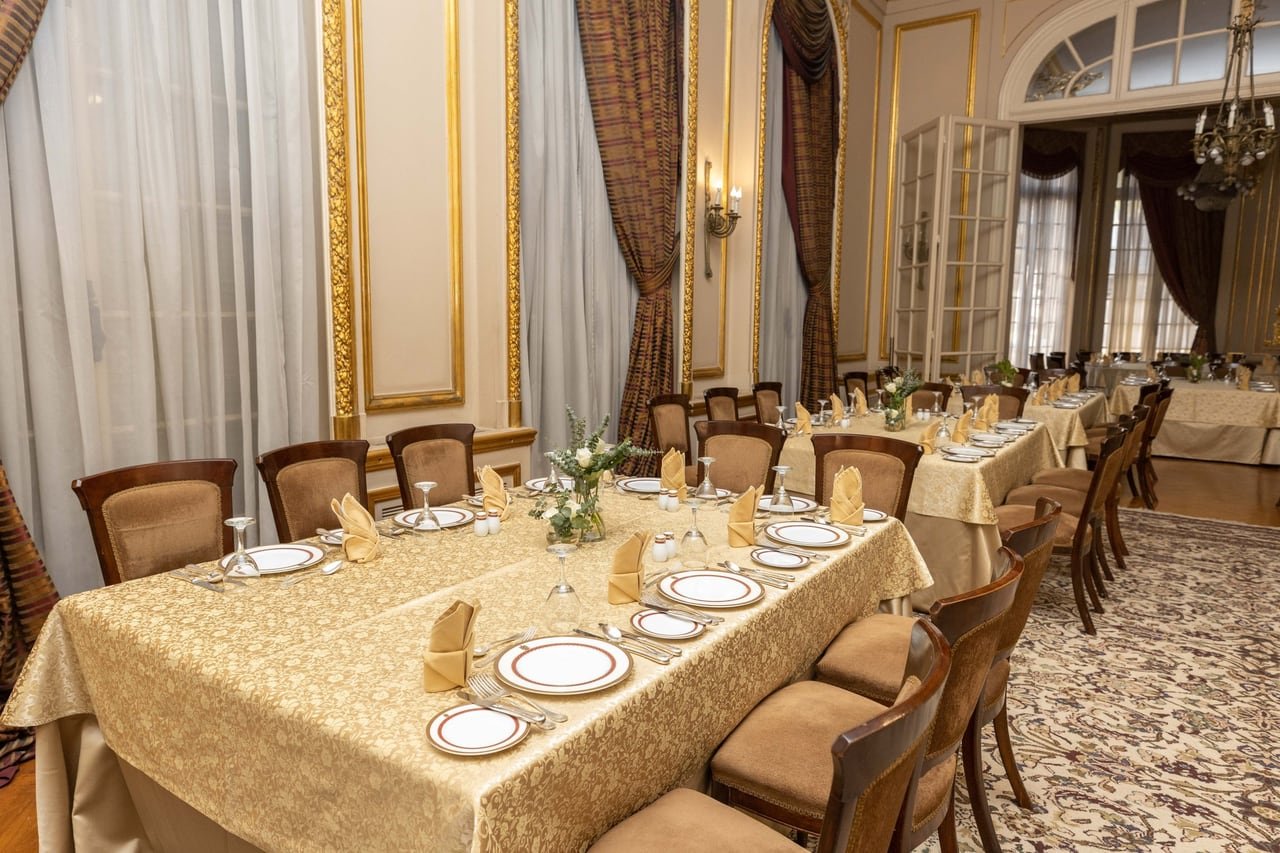 A table set with plates and gold napkins.