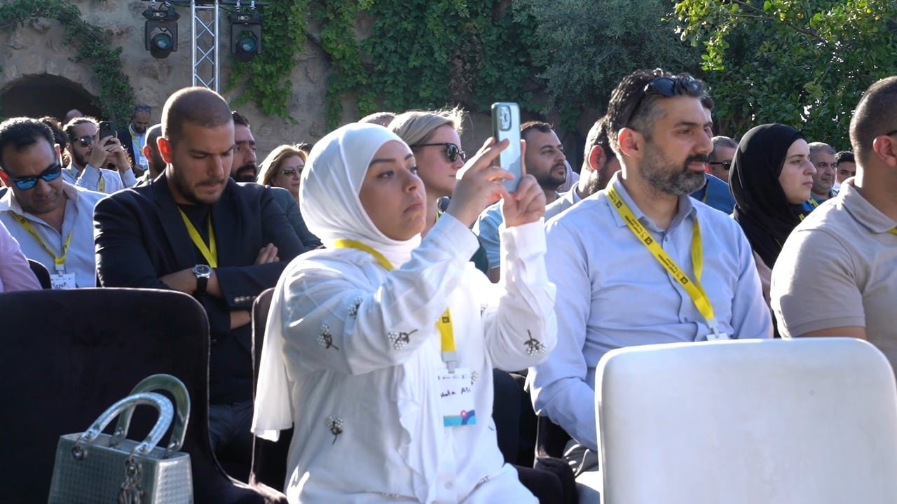 ضيوف يصوّرون المسرح من مقاعدهم.