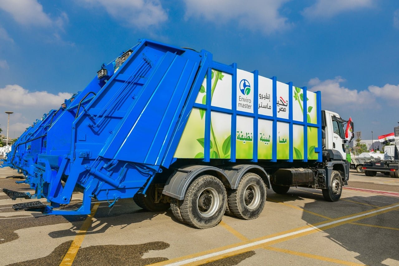 A new blue waste-collection truck, side-on under a clear sky.