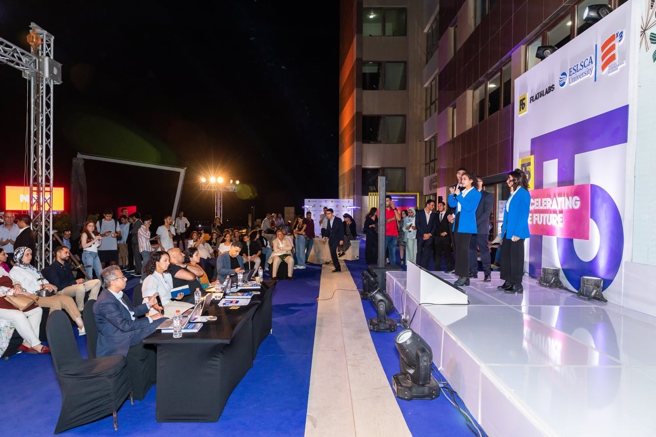 The audience around the long runway stage after dark.