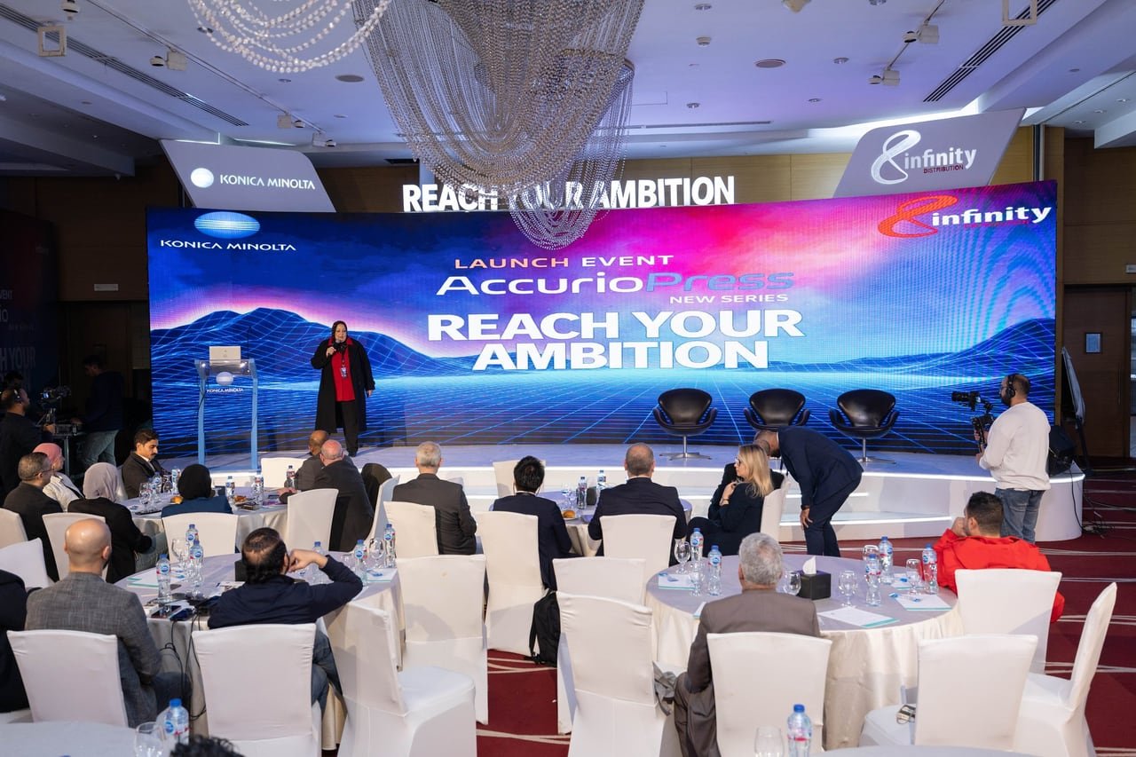 Guests at round tables facing the LED stage at the AccurioPress New Series launch.