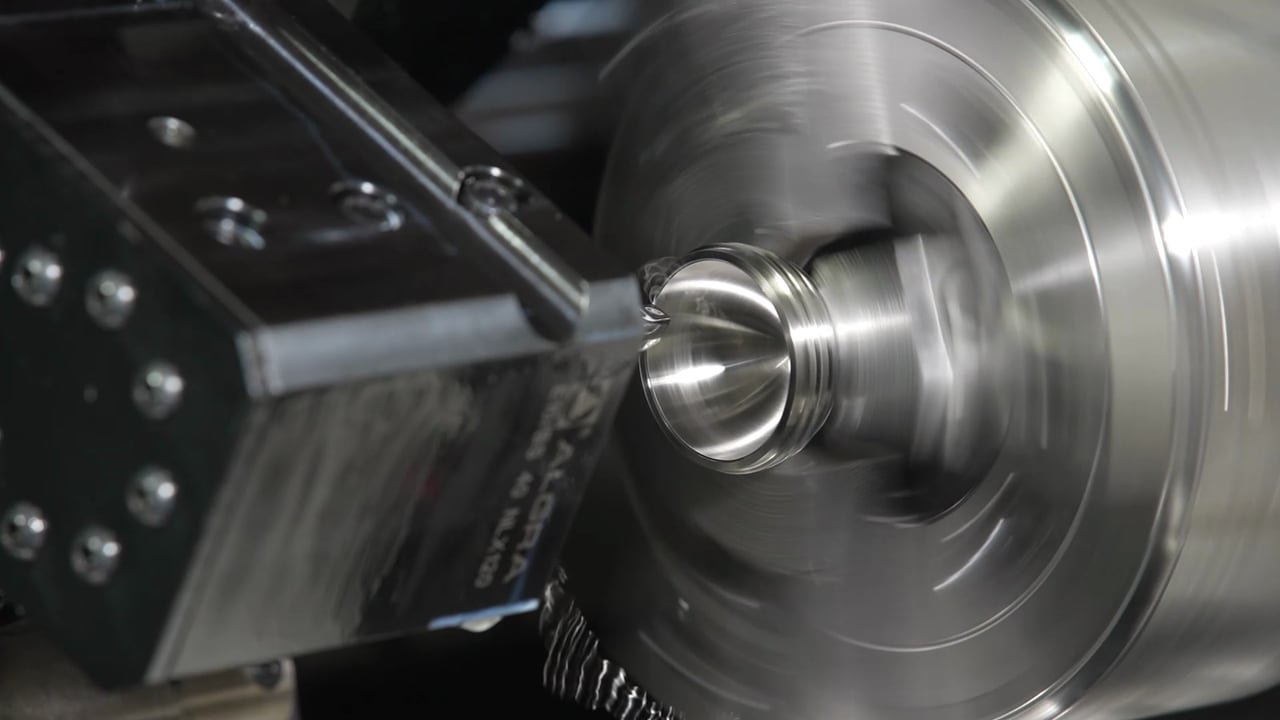 A lathe turning a metal part, in close-up.