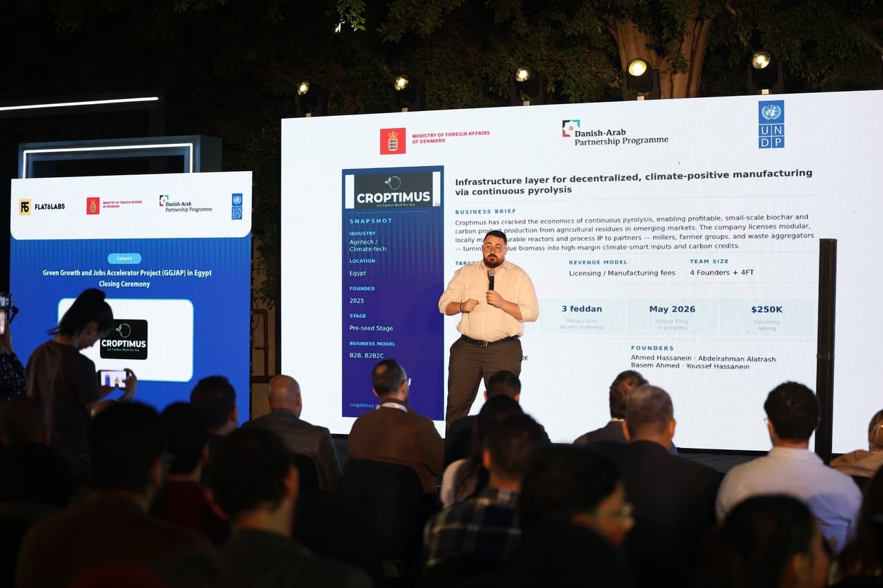 A founder pitching to a seated audience at night.