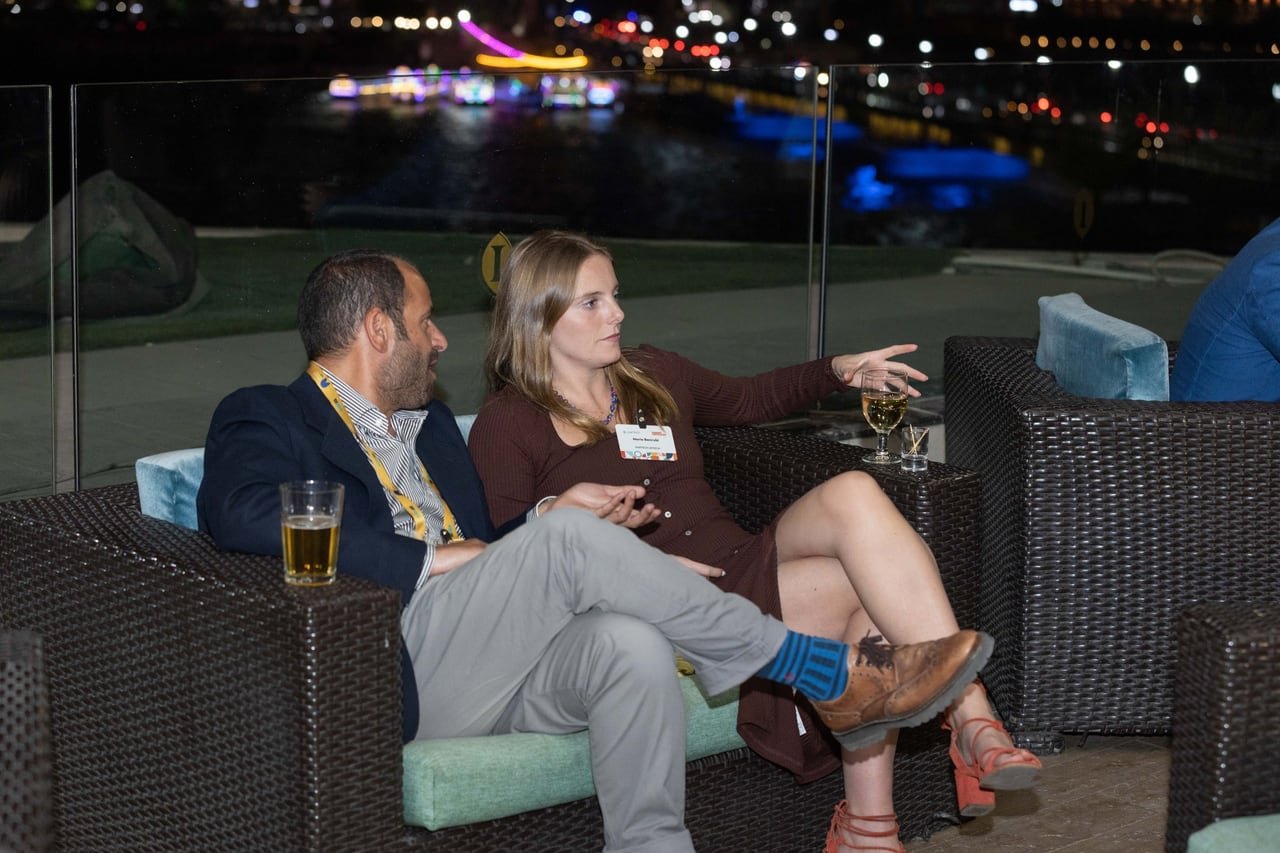 Two guests on the lounge sofas, the Nile lights behind them.
