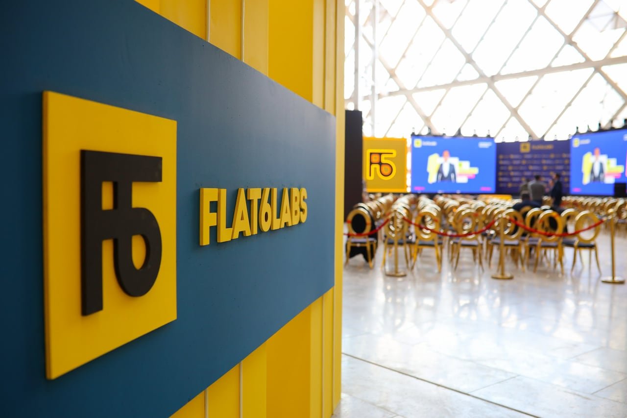 The Flat6Labs sign in close-up, with the hall behind it.
