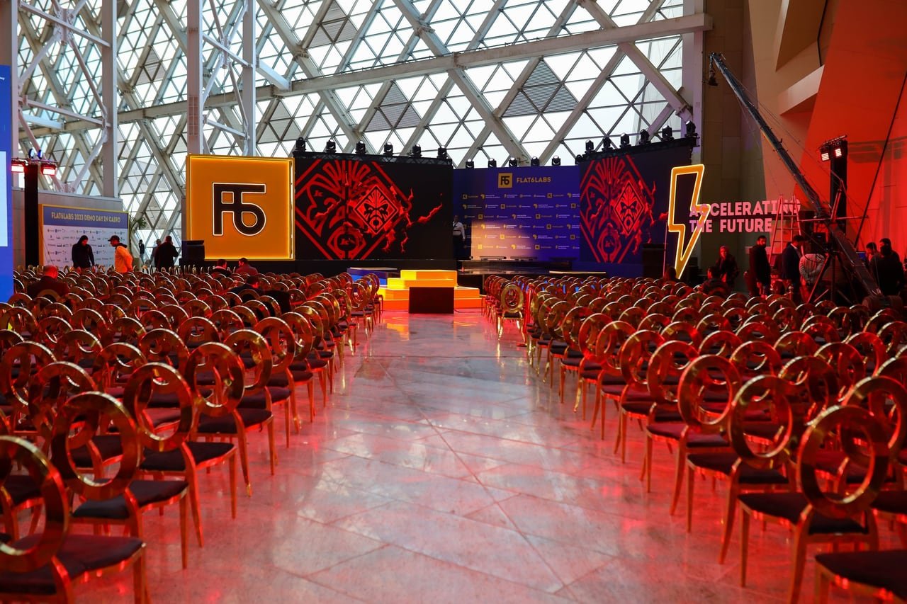 The hall under red lighting, the aisle leading to the stage.