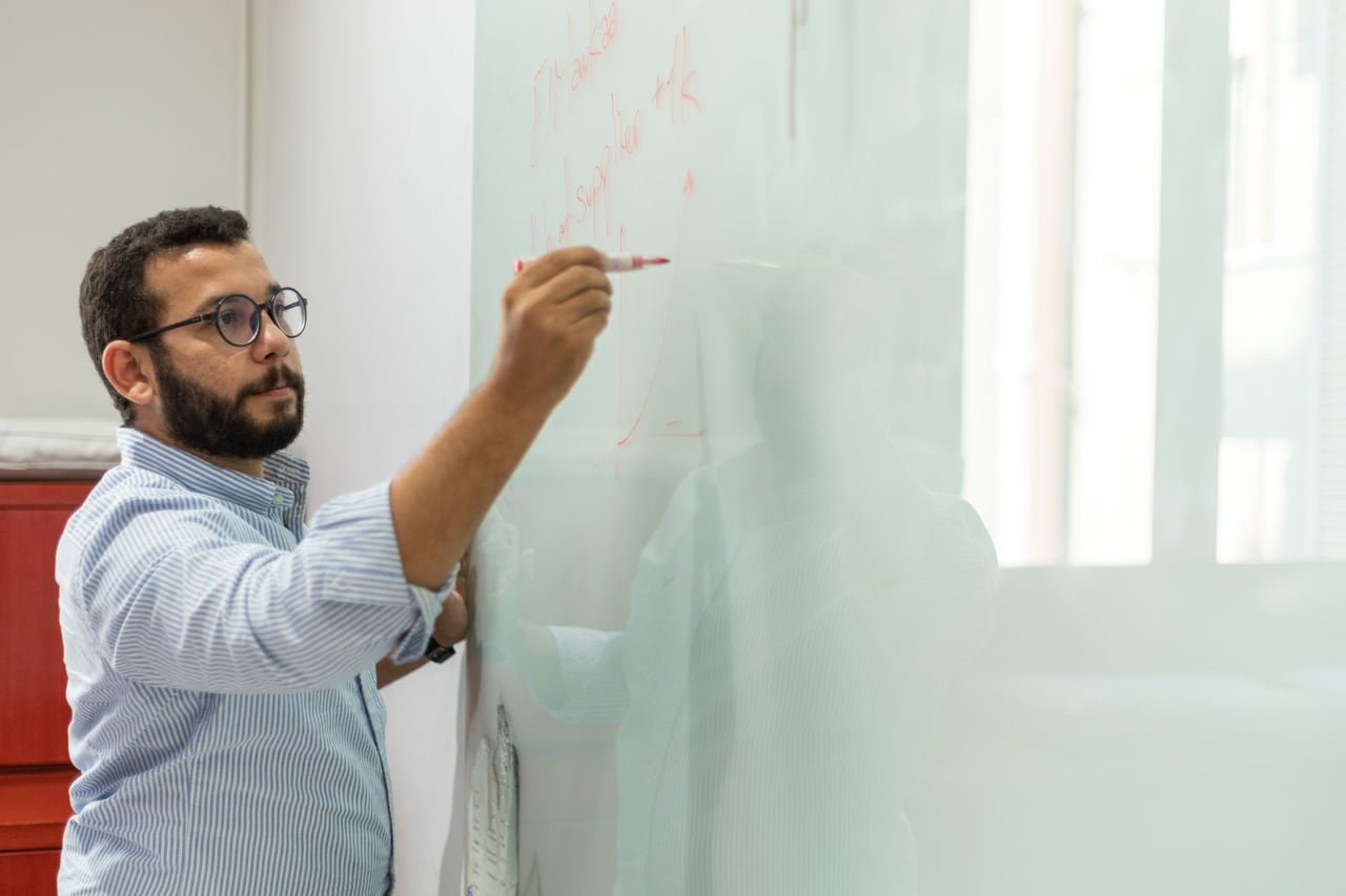 A founder writing on the whiteboard.
