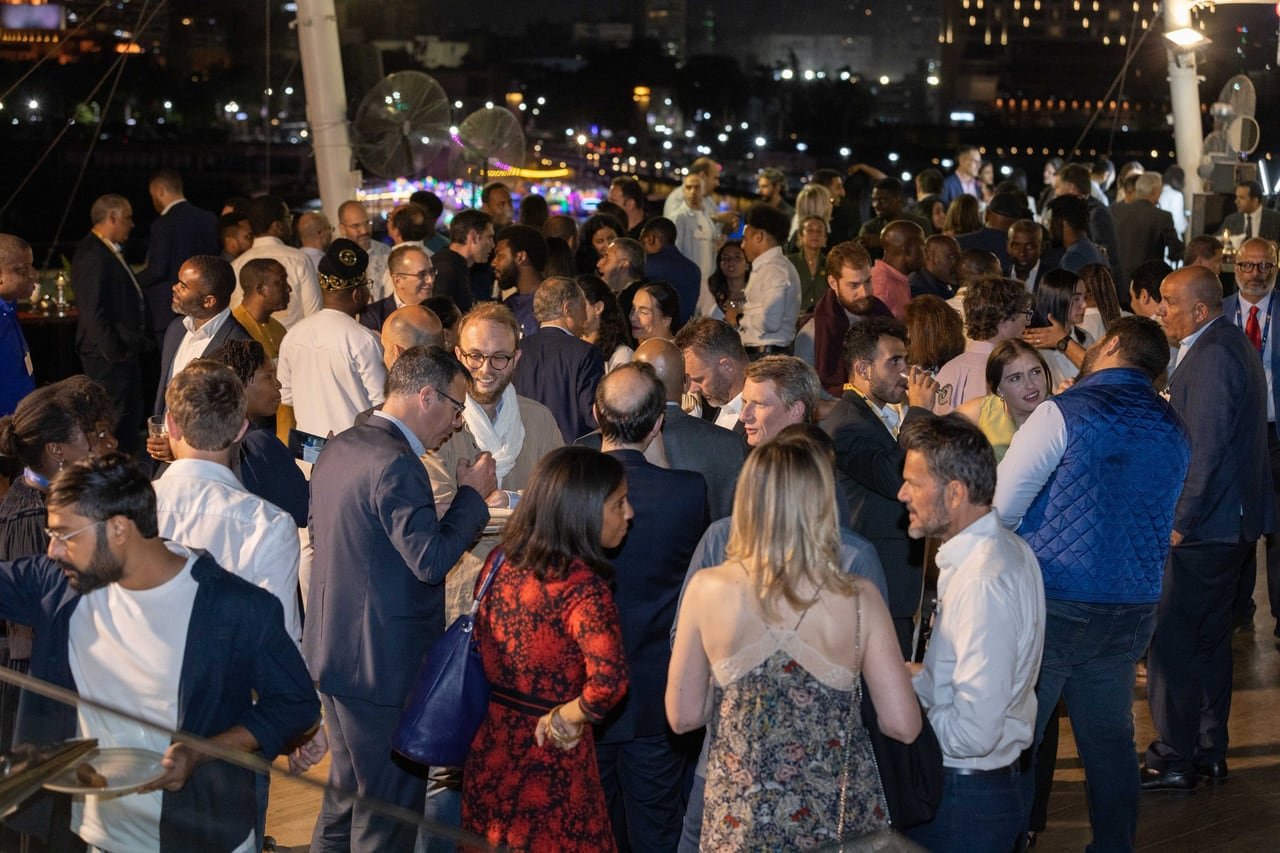 A crowd of conversations on the rooftop after dark.