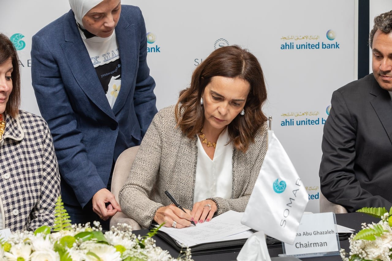 The agreement being signed at the flower-dressed table.