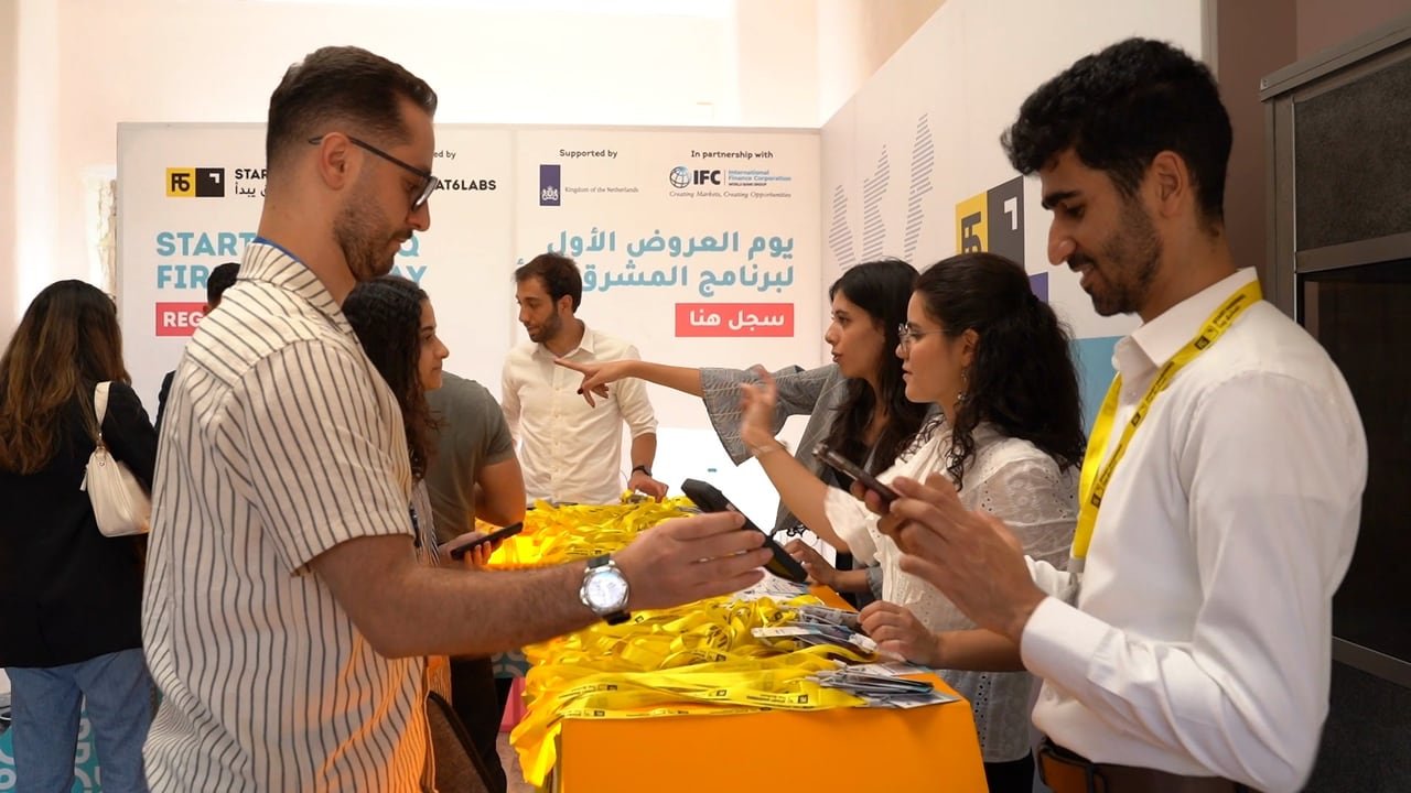 ضيوف يستلمون بطاقاتهم عند التسجيل.