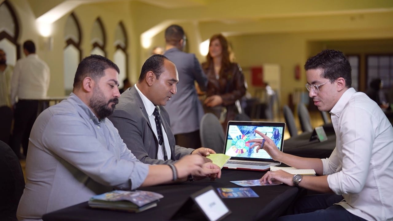 A founder showing his startup to investors at a table.