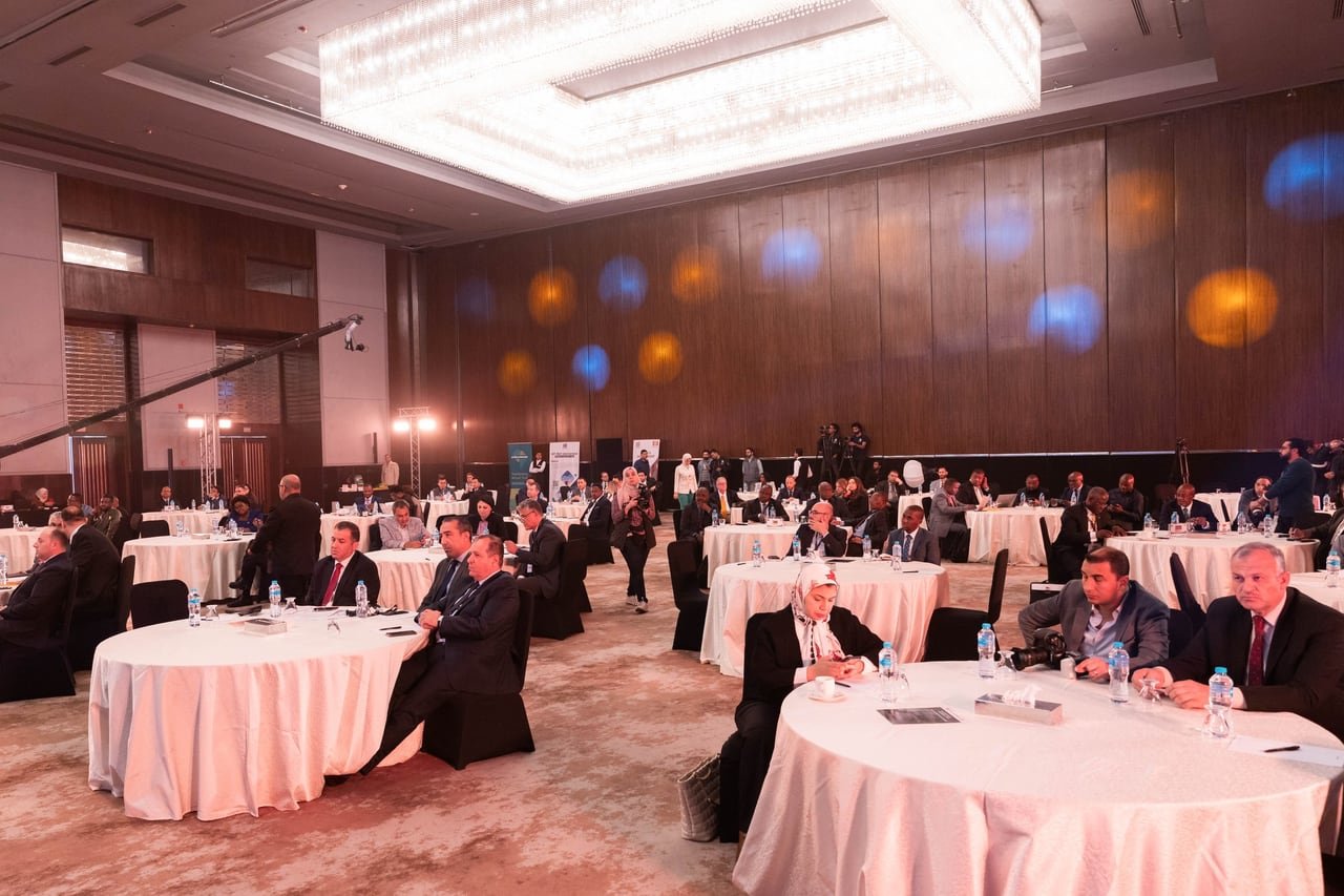 Guests at round tables under the ballroom chandeliers.