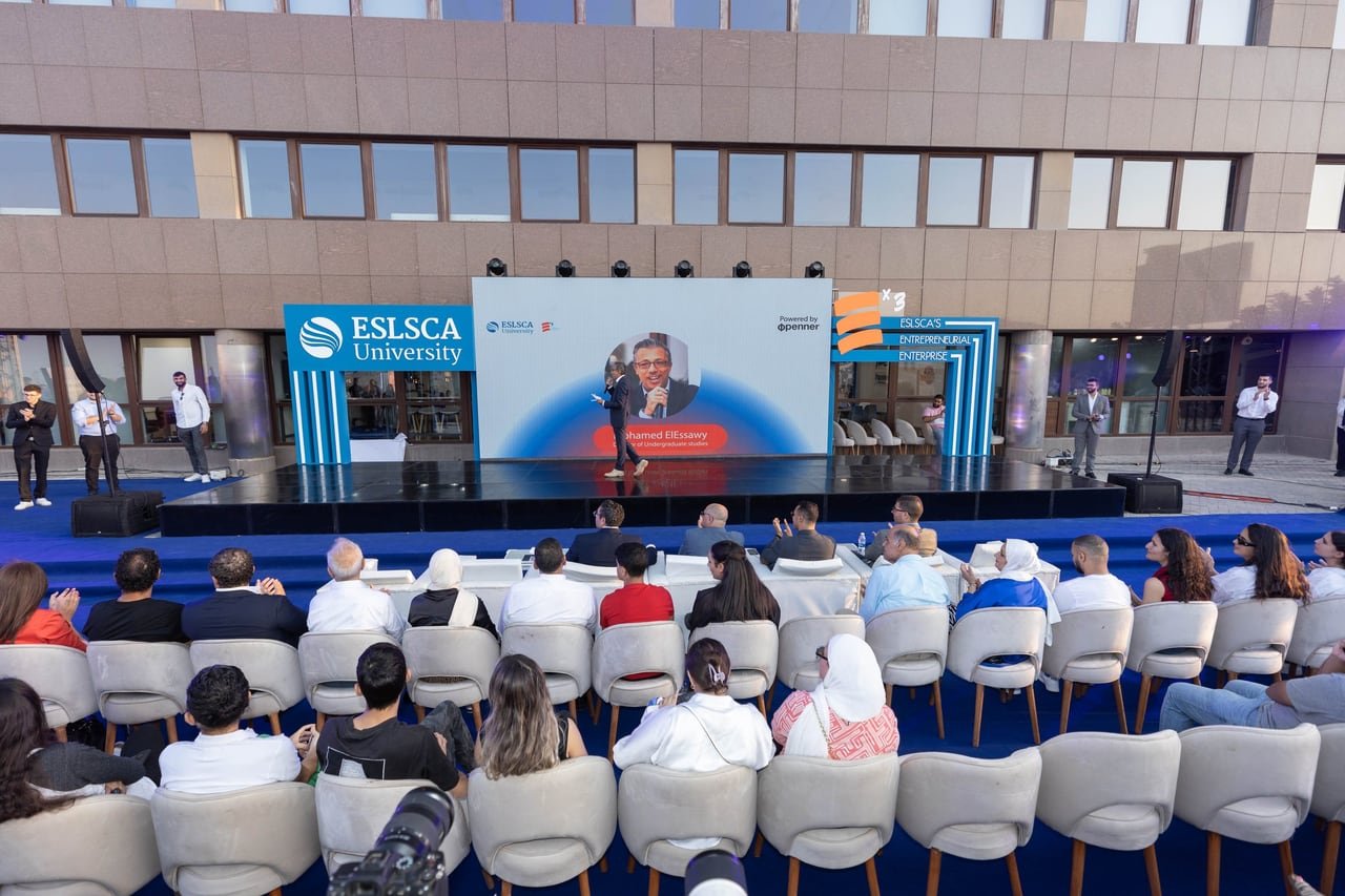 The audience watching a pitch in the courtyard.