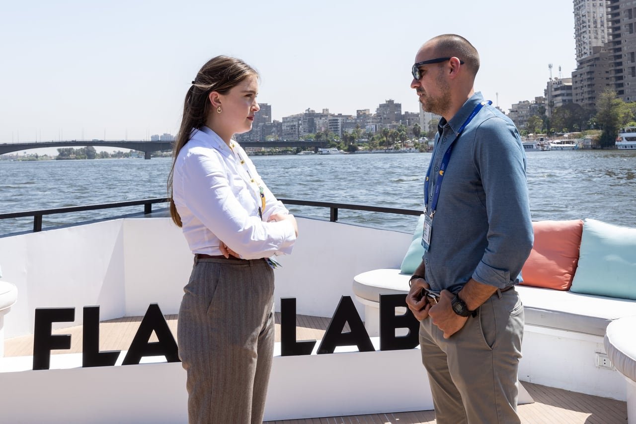 Two guests talking on deck with the Nile in the background.
