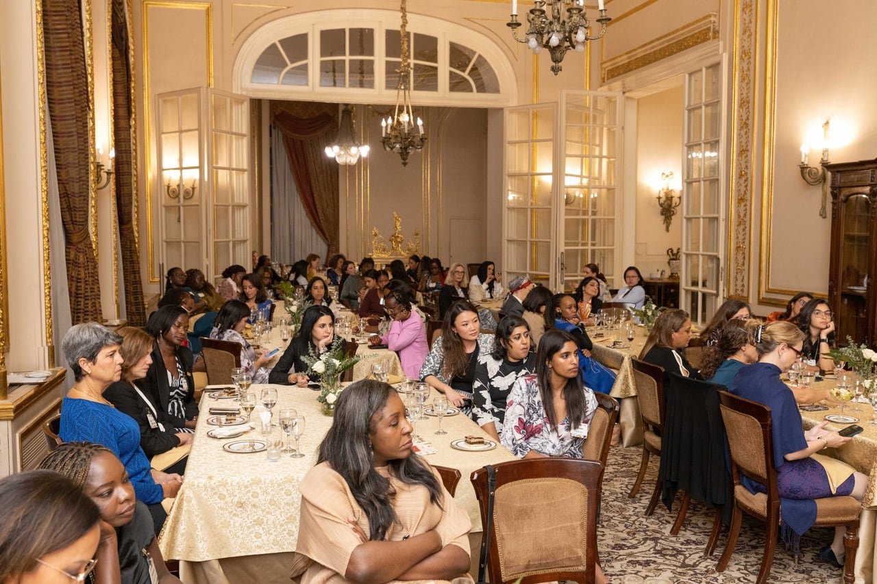 Guests at the dinner tables under the chandeliers.