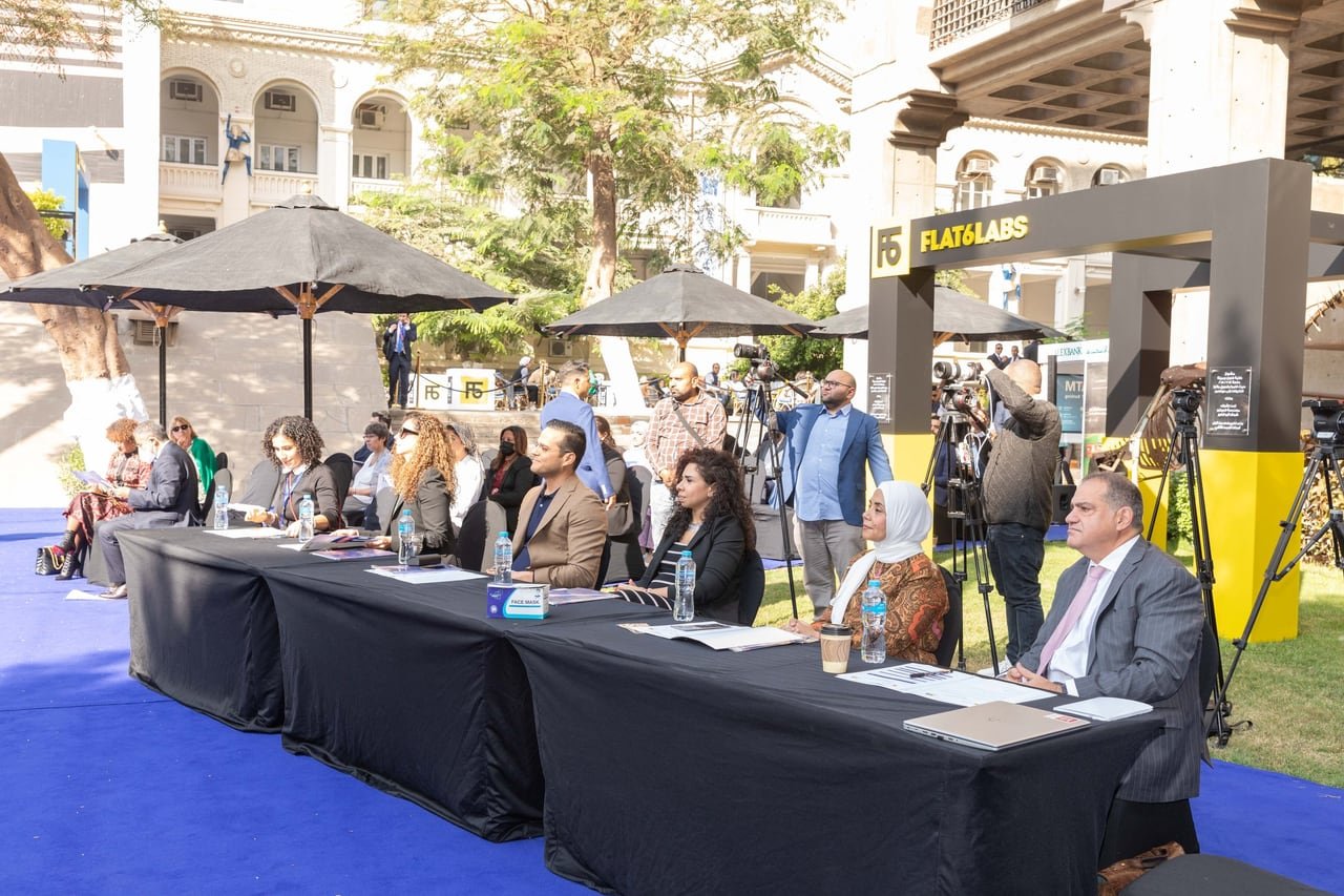 The jury at its long table on the blue carpet in the courtyard.
