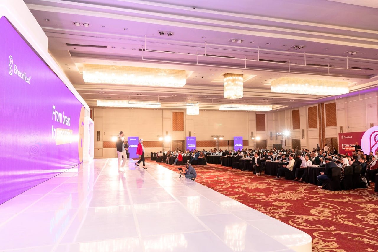 The white runway leading to the Breadfast stage in a full ballroom.