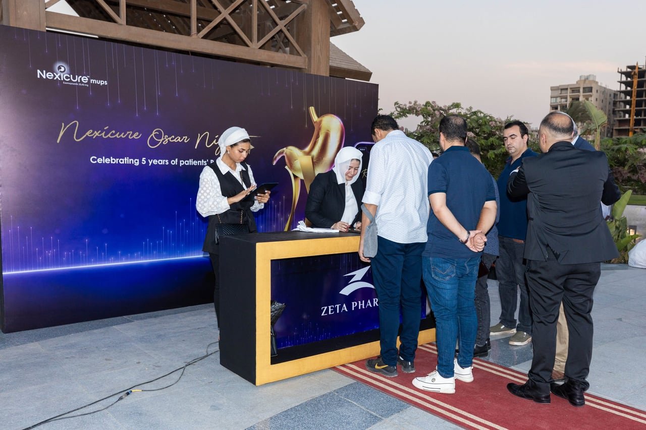 Guests at the registration desk beside the golden statue.