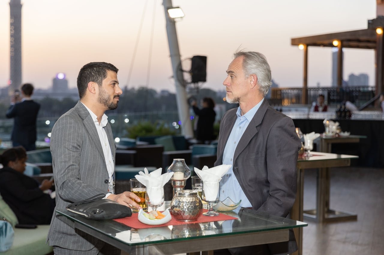 Two guests talking at a table overlooking the Nile.