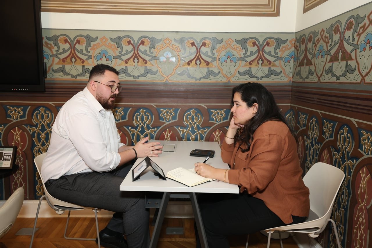 A founder and an investor in a one-to-one meeting at a small table.