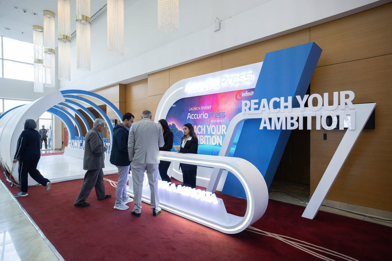 Guests walking past the Reach Your Ambition set at the AccurioPress launch.